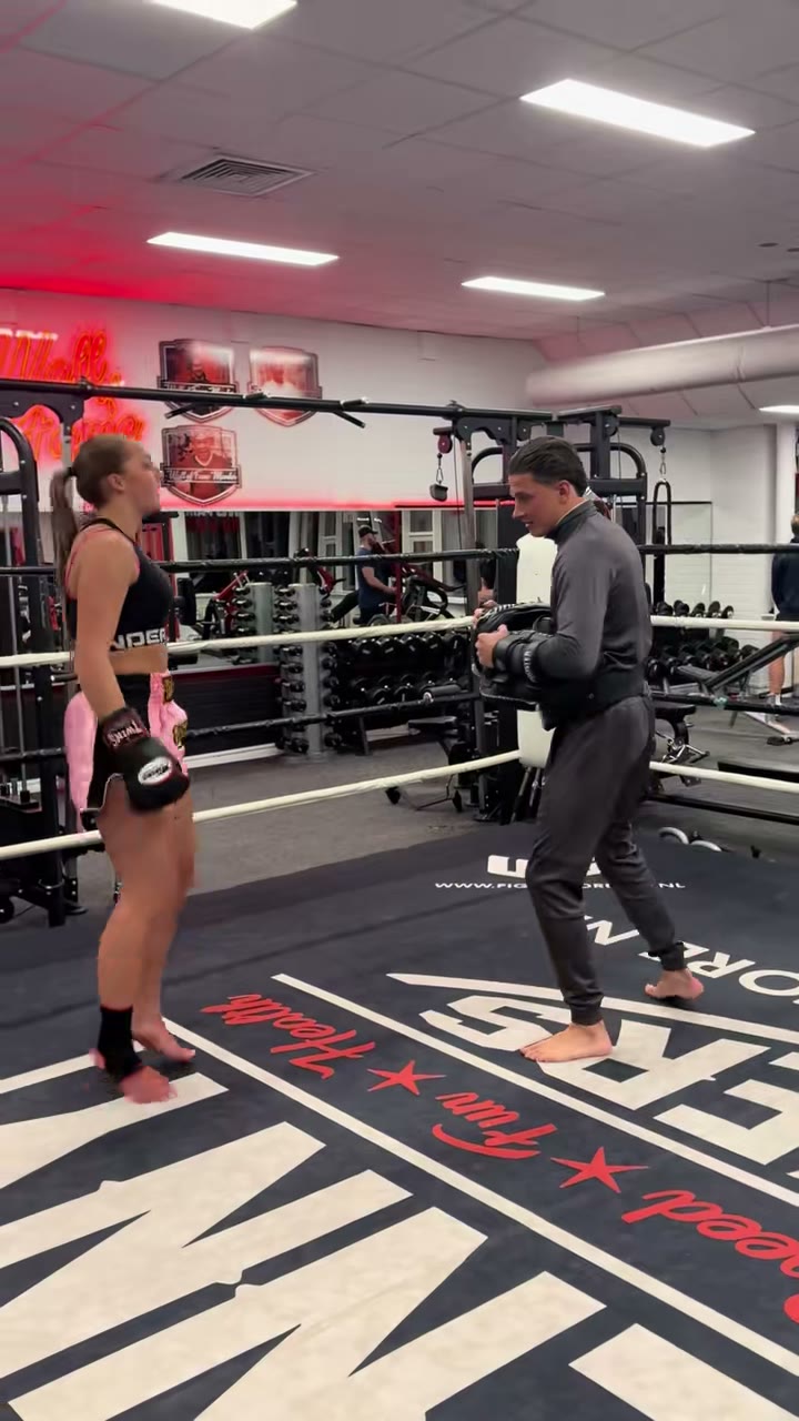Een trap op de pads tijdens kickbokstraining